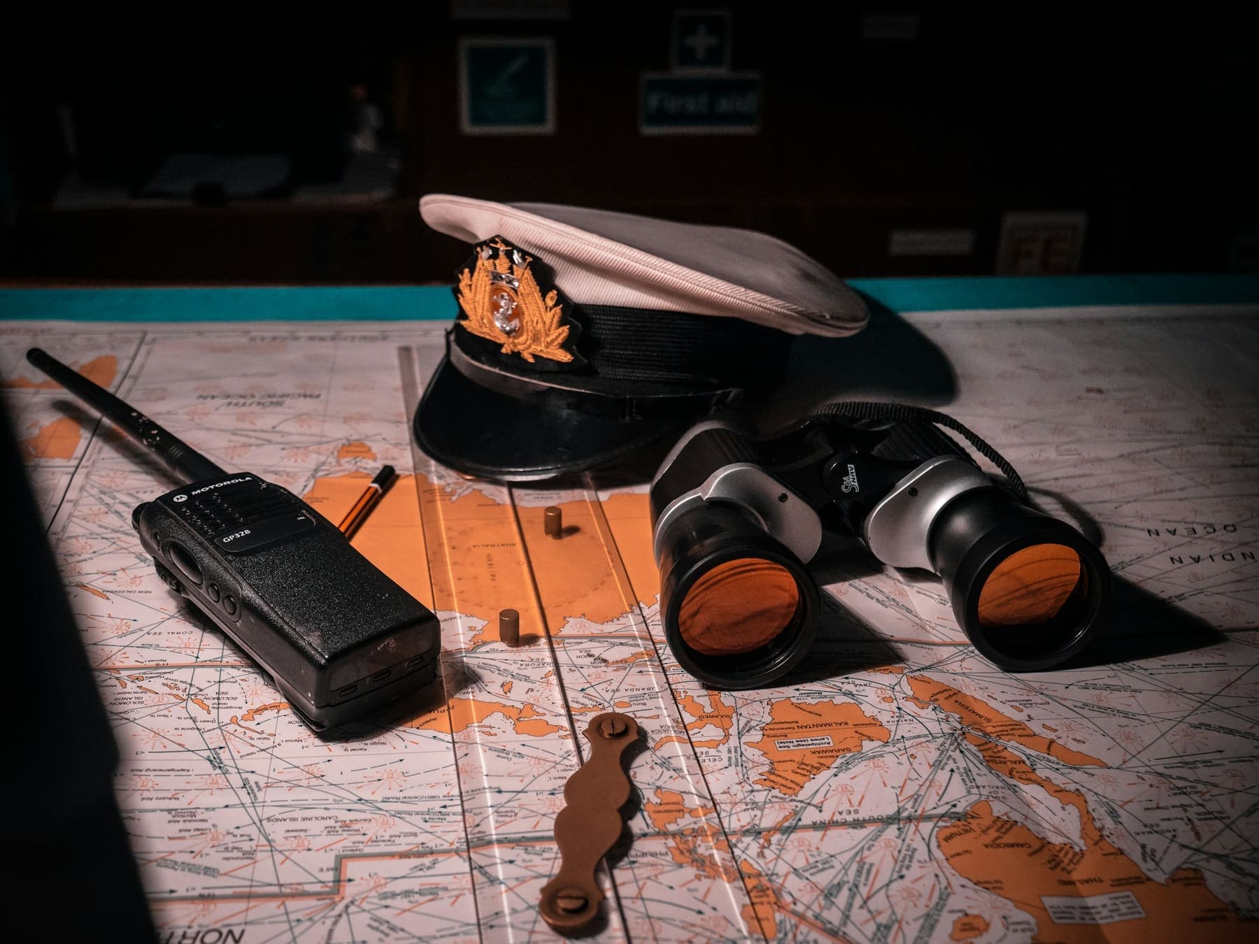 Handheld radio on a map next to binoculars, ready for channel planning
